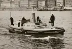 Ångslup, möjligen tillhörande svenskt pansarskepp. I bakgrunden Skeppsbron.