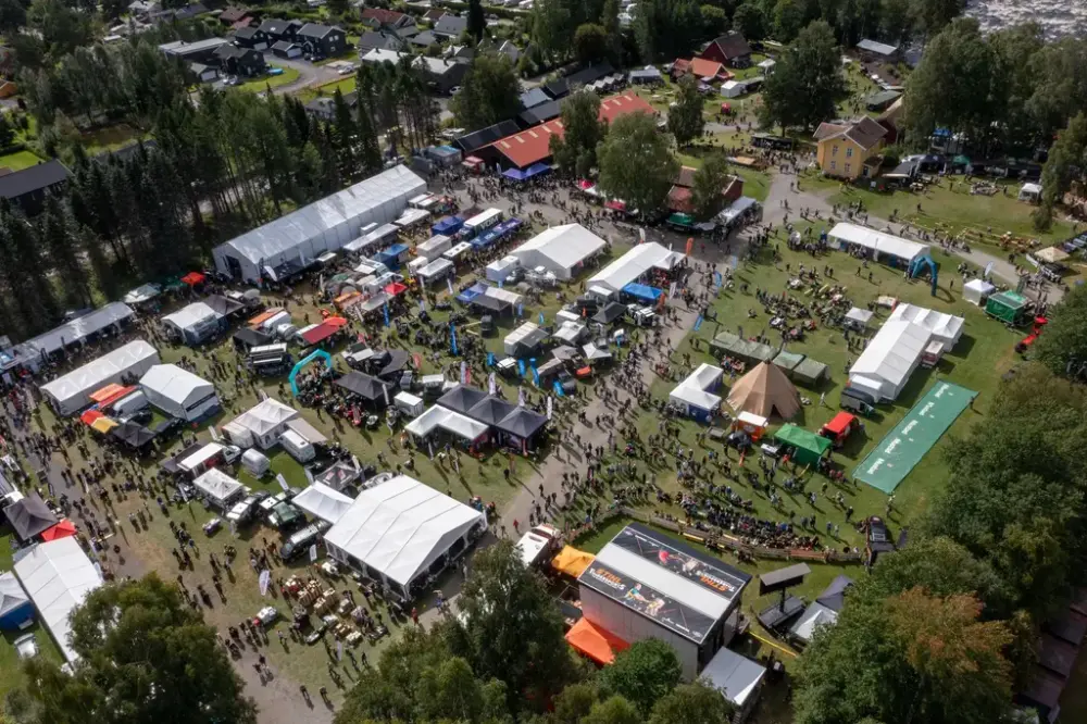 Flyfoto med drone over festivalområdet med telt og folkemengder under De nordiske jakt- og fiskedagene.