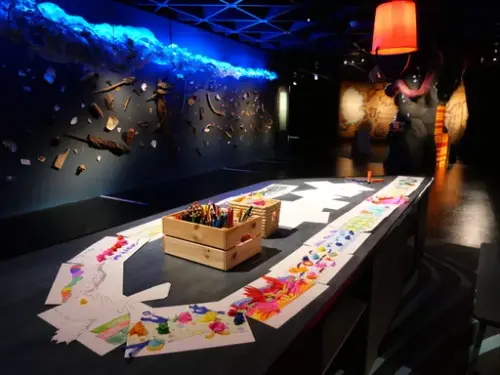 Kreativt kunstverksted med fargerike tegninger og kunstmateriell.