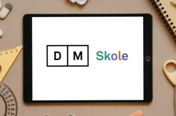 Nettbrett med DM Skole-logo, på bakgrunn med skolemateriell