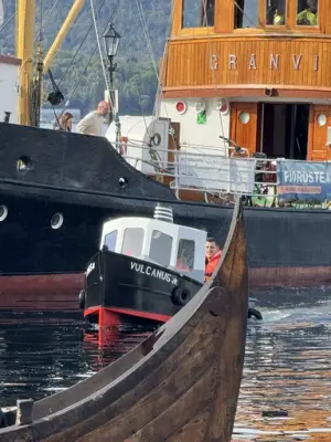 Vi ser litt av et vikingsskip, en lite båt som heter Vulcanus og litt av dampbåten Granvin