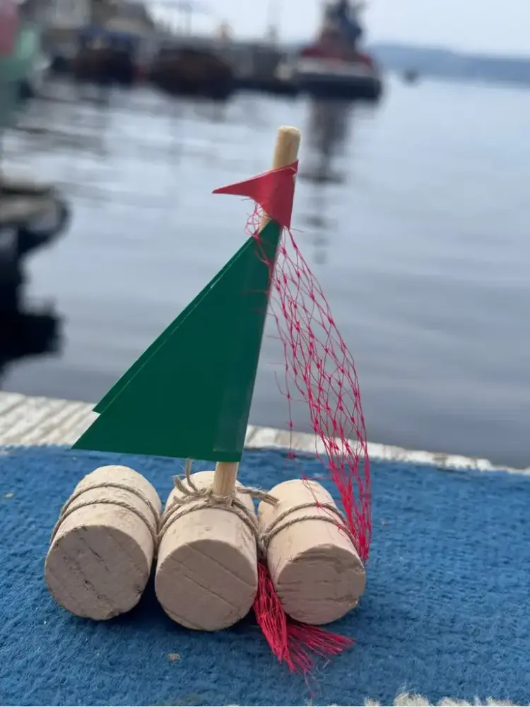 VI ser en fin båt, laget av vinkorker, med segl og spinnaker