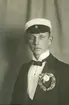 En ung man i studentmössa och smoking.
Bröstbild, halvprofil.
Trol. Seved Svensson, student v. Växjö läroverk 1913.