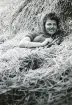 Gunnel Persson Hultin vilar i höet, 1944 (enligt text i album). Text baksida kort: 