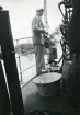 Man i kostym och skärmmössa ombord en båt. Sjömanöver 1946. Text i album: 