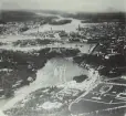 Flygbild med tillägg av inretuschrade byggnader och anläggningar för Stockholmsutställningen 1930. Vy mot väster. 
Utställningen innefattade området för tidigare K. Livregementets Dragoners kasern- och stallområde på Norra Djurgården.