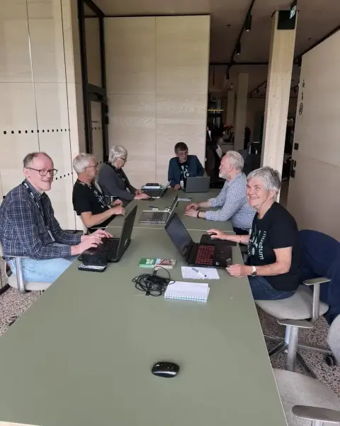 Representanter for ulike slektshistorielag sitter rundt et langbord på lesesalen i historiesenteret på Domkirkeodden.