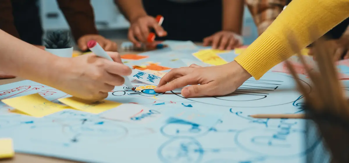Händer som skriver på papper och post-it-lappar