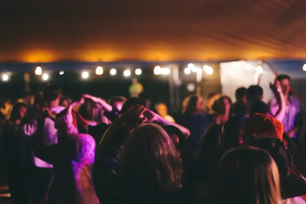 dansende mennesker i lilla lys