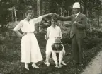Tre kvinnor i ljusa sommarklänningar och en man i kostym spexar utomhus. Längst ner i mitten syns Ruth Svensson, som 
verkar ha bytt hatt med mannen.