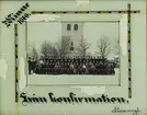 En konfirmationsklass har samlats med prästen framför kyrkan i Linneryd.
Inglasat foto med ljust turkos passepartout med dekorationsbård i svart, vitt och guld på tre sidor och text:
