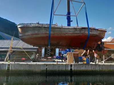 Vi ser føringsbåten Markol fra siden når den heises på land for restaurering