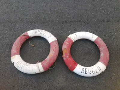 Vi ser to gamle og delvis falmede redningsbøyer, originale fra føringsbåten Markol