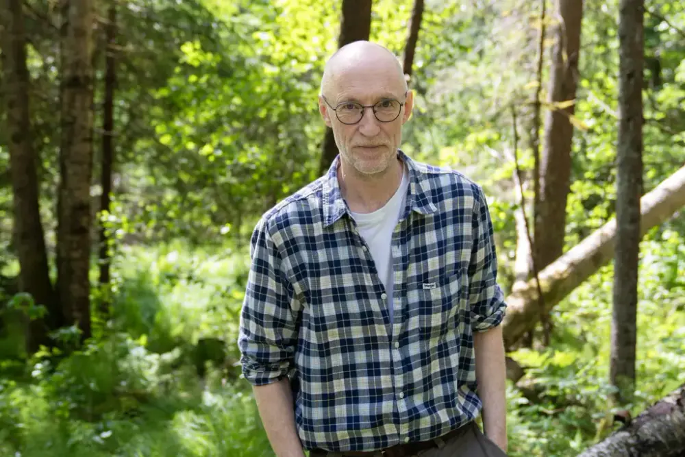 Mann med rutete skjorte i skogen