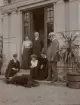Hofors herrgård; Fredrik Ulfsparre (till vänster i bild), troligen föräldrarna Hanna Ulrika och J. A. Ulfsparre vid dörren. Disponent Per Eriksson till höger i bild, Hedvig Ulfsparre sittandes brevid honom med en hund samt en ej namngiven kvinna brevid Hedvig.