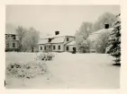 Två flygelbyggnader vid Kungsgåredens herrgård vintertid. Till vänster i bild skymtas herrgårdsbyggnaden.