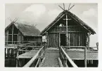 Historiska vetenskapliga rekonstruktioner av pålbyggnader från stenåldern, cirka 2200 f.Kr. vid Pfalbaumuseum, Unteruhldingen, Tyskland. Till höger bostadshus, till vänster samlingshus.