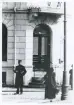 En poliskonstapel har stannat till i vimlet framför ingången till dåv. Spritbolaget i hörnet Klostergatan/Norra Järnvägsgatan, ca 1913. 
Utsnitt ur större foto (BELA0073-a).