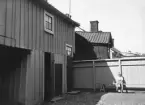 Besök i miljö som skulle komma att bevaras som del i de så kallade Hantverksgårdarna i Linköping. Gårdsinteriör från Hunnebergsgatan 7. Foto 1937 eller möjligtvis 1938.
