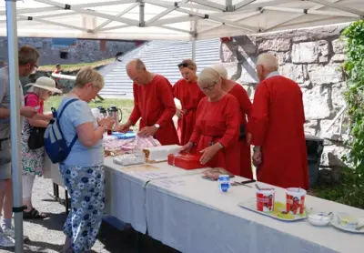 Medlemmer av Domkirkeoddens venner bidrar hvert år med salg av kaffeog sveler under Hamar Middelalderfestival. Da har alle medlemmene på seg flotte, røde middelalderdrakter.
