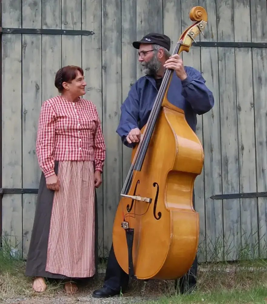 En kvinna och man framför en äldre port och där mannen håller en cello.