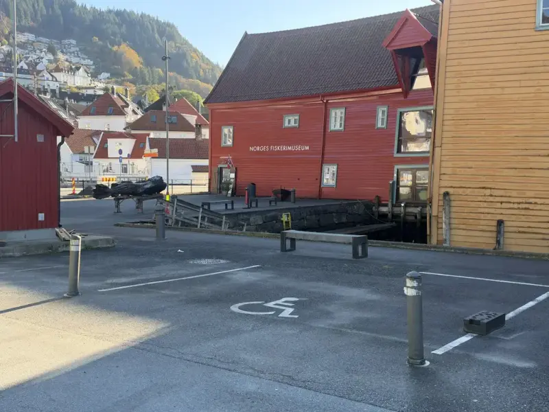 I bildet ser vi parkeringsplass med HC symbol i forgrunnen og museet i bakgrunn