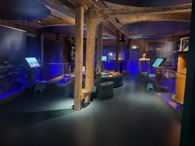 VI ser utstillingen fra høyre siden når vi kommer inn, med de ulike fordypningstasjonene langs sidene og aktiviteter i midten. Alt utenfor gjerdet langs sidene er taktilt